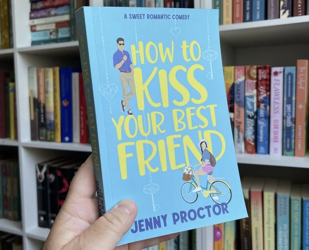 Hand holding the book "How to Kiss Your Best Friend"