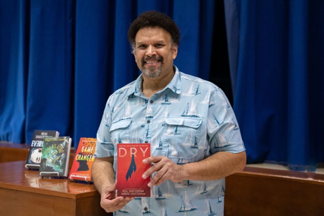Neal Shusterman holds a book in his hands