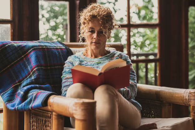 Woman reading a book while sitting in a chair